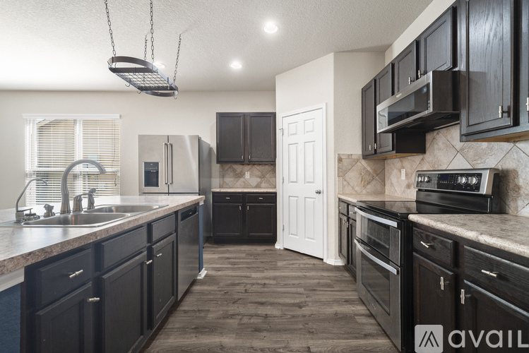 A kitchen with black cabinets and a white door.