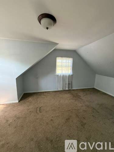 A room with a window and a ceiling fan.