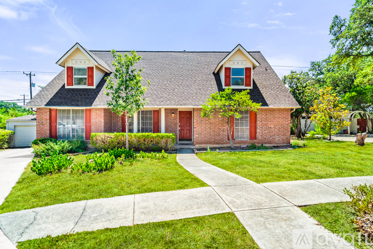 A red brick house with a white window and a grey roof.