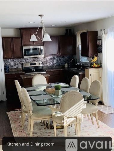 A kitchen and dining room with a glass table and chairs.
