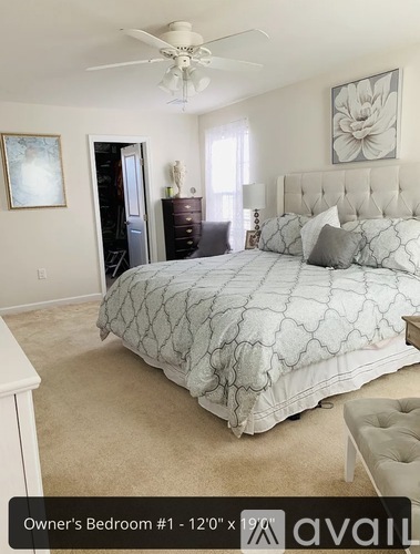 A bedroom with a large bed and a ceiling fan.