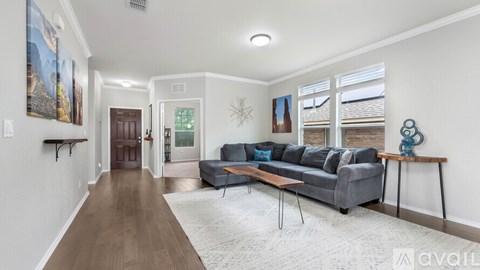 A living room with a grey couch and a wooden table.