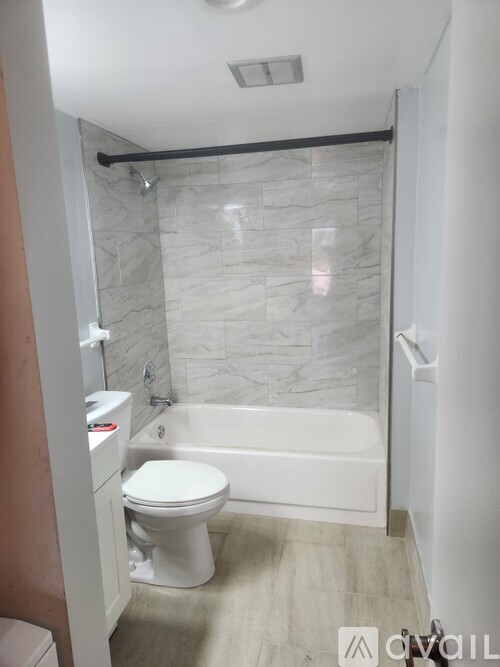 A white toilet sits next to a bathtub in a bathroom.