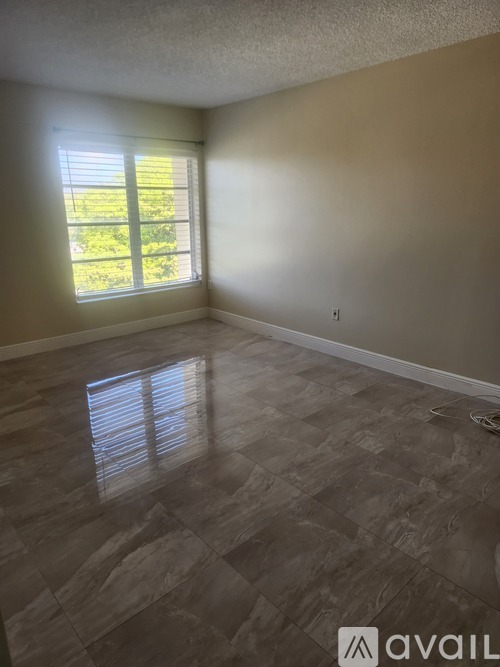 A room with a large window and a tiled floor.