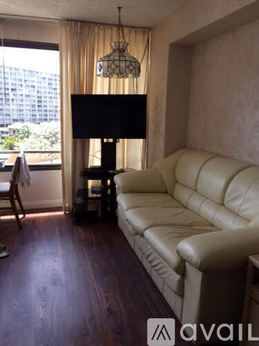 A living room with a white couch and a lamp.