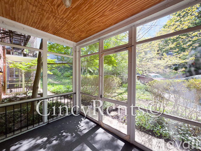 A balcony with a view of a garden and trees.