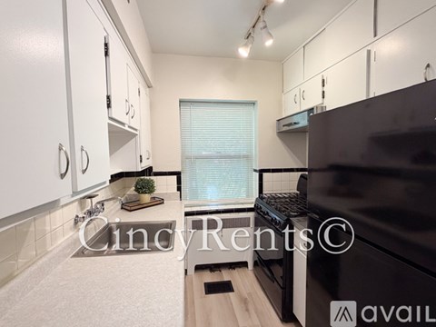 A kitchen with white cabinets and a black oven.