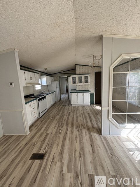 A kitchen with wooden floors and white cabinets.