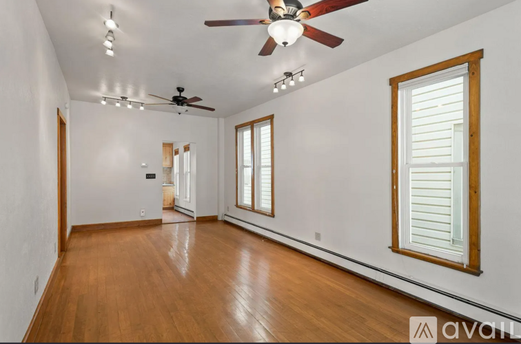 A room with wooden floors and a ceiling fan.