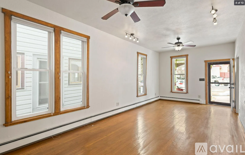 A room with a wooden floor and a ceiling fan.