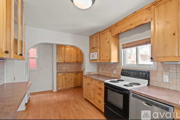 A kitchen with wooden cabinets and a black stove top oven.