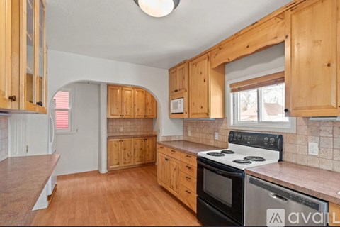 A kitchen with wooden cabinets and a black stove top oven.