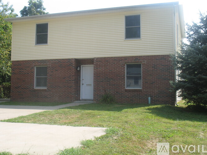 A two-story house with a white door and windows.