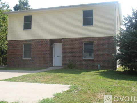 A two-story house with a white door and windows.