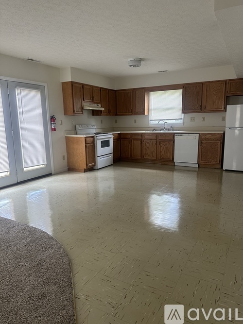 A kitchen with wooden cabinets and a white fridge.