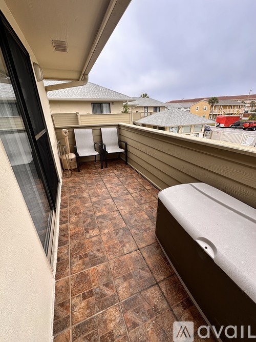 A patio with a hot tub and a view of the street.
