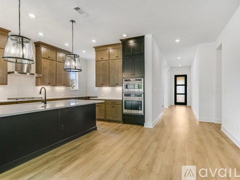 A modern kitchen with wooden cabinets and a black countertop.