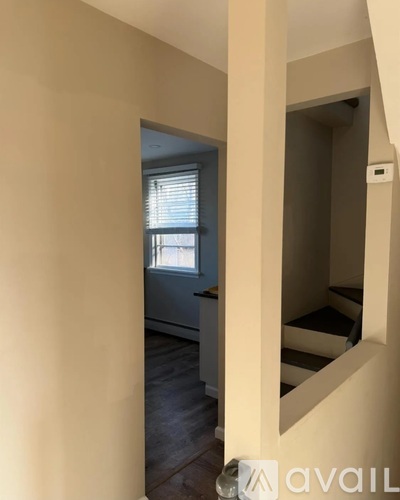 A hallway with a staircase leading to the second floor.