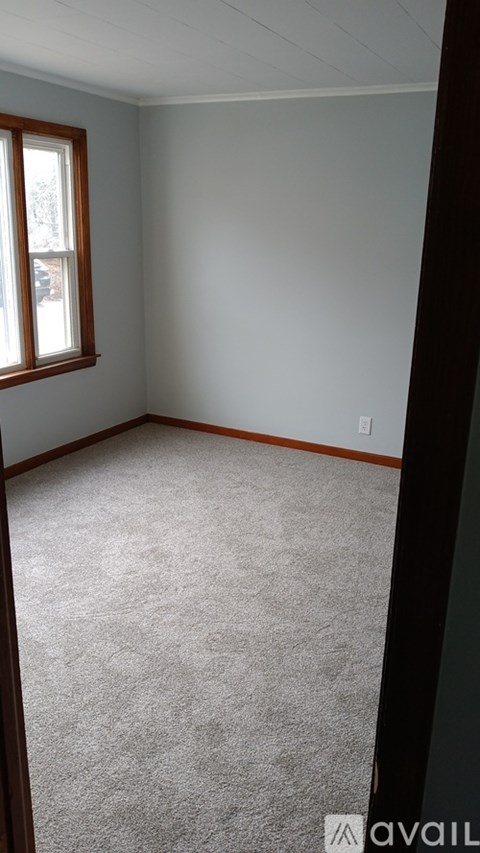 A room with a carpeted floor and a window.