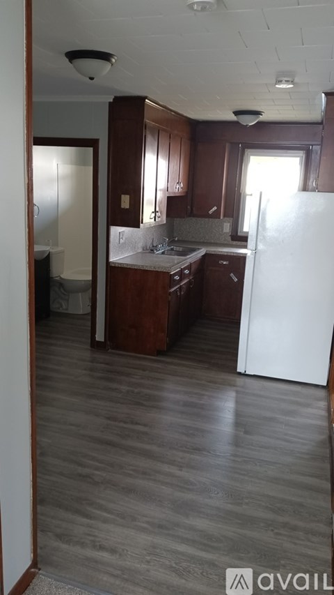 A kitchen with wooden cabinets and a white refrigerator.