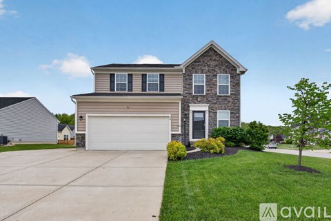 A house with a garage and a driveway in front.