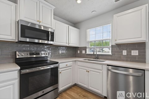 A kitchen with white cabinets and a black stove top oven.