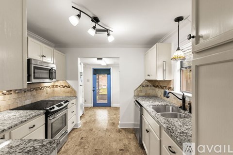 A kitchen with granite countertops and a stove top oven.