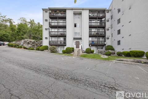 A parking lot in front of a multi-story apartment building.