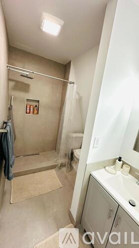 A bathroom with a shower, sink, and mirror.