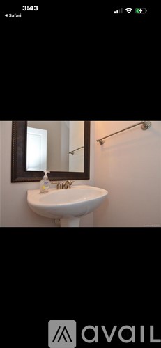 A white sink in a bathroom with a mirror above it.