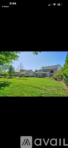 A house with a white exterior is surrounded by greenery.