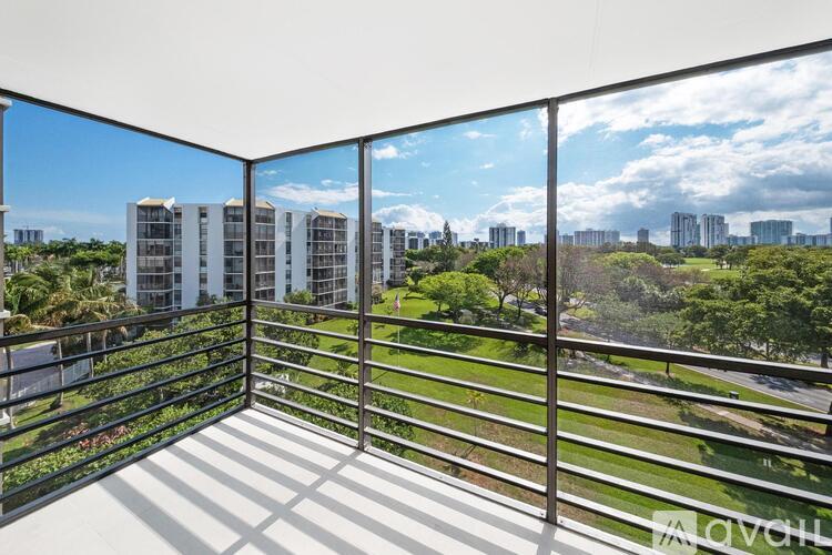 A balcony with a metal railing overlooks a cityscape.