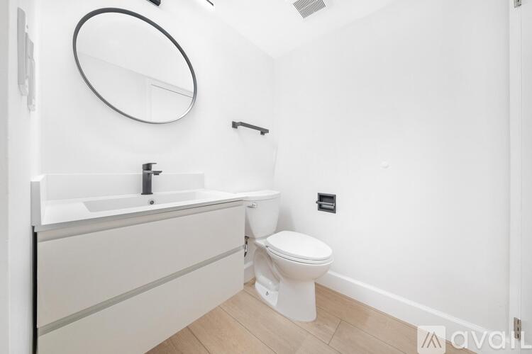 A white toilet sits next to a sink in a small bathroom.