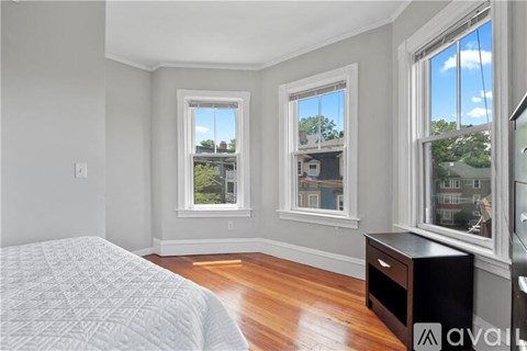 A bedroom with a large bed and two windows.