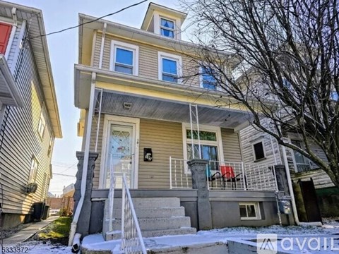 A two-story house with a balcony and a red chair on the balcony.
