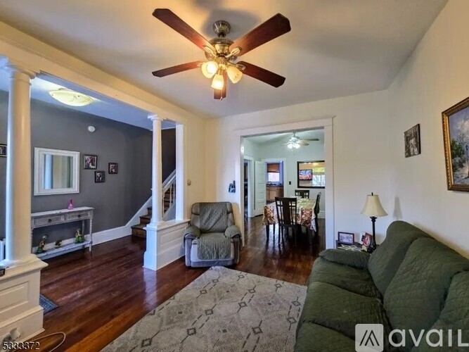 A living room with a green couch and a ceiling fan.