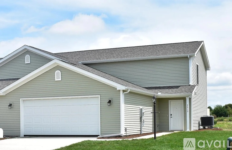 A house with a grey siding and a white garage door.