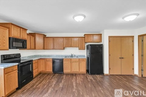 A kitchen with wooden cabinets and black appliances.
