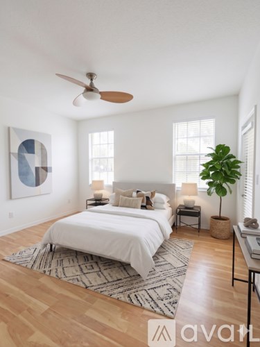 A bedroom with a large bed and a ceiling fan.