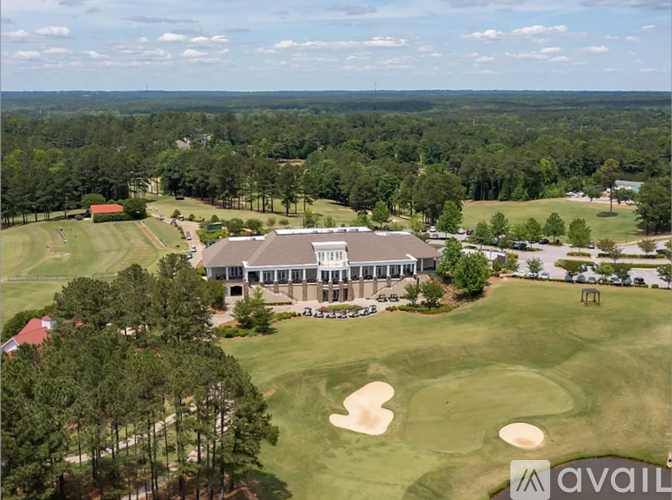 A golf course with a clubhouse and a parking lot.