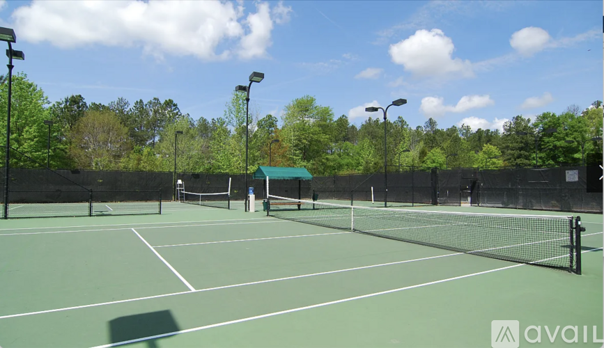 A tennis court with a net and trees in the background.