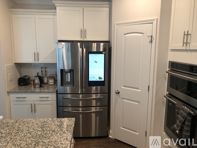 A kitchen with a refrigerator and a microwave on top of it.