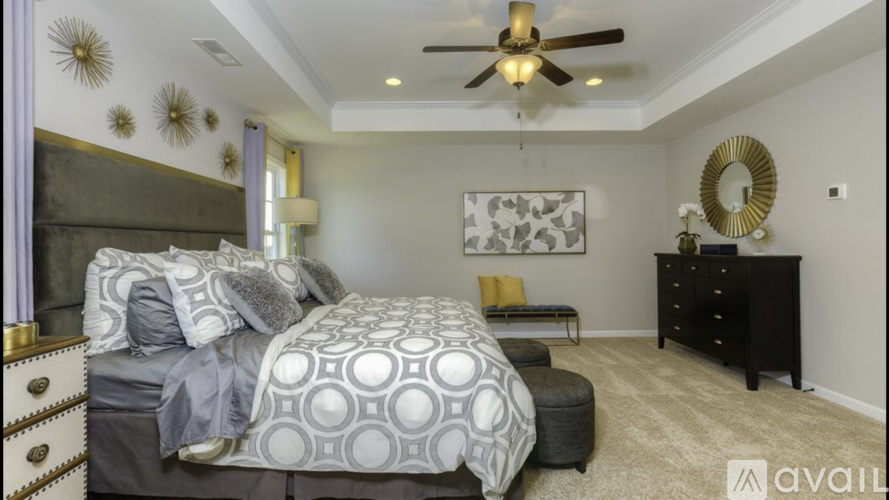 A bedroom with a large bed and a ceiling fan.