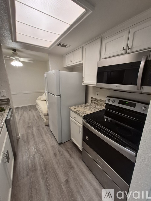 A kitchen with a stove top oven and a refrigerator.