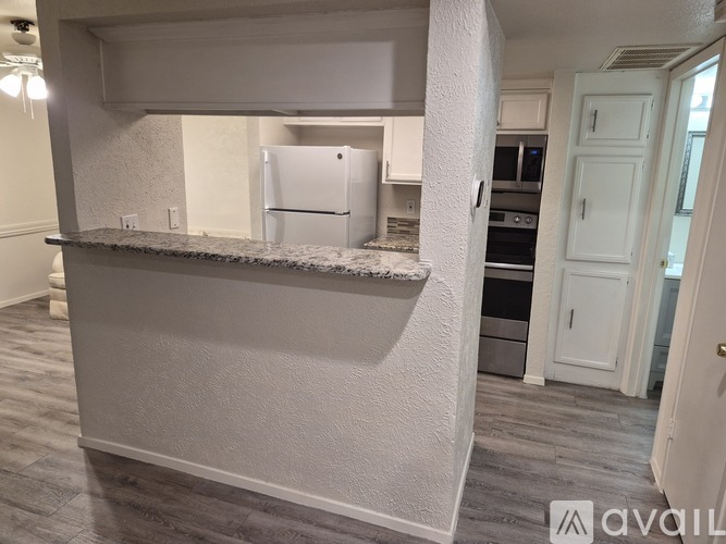 A kitchen with a white fridge and cabinets.