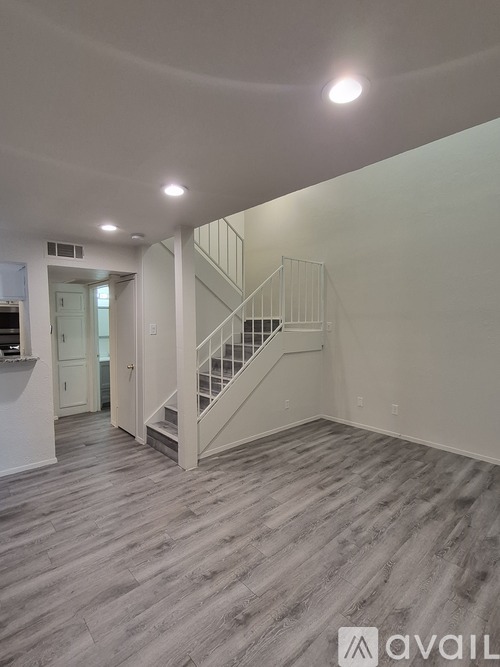 A spacious room with a staircase and a logo that reads "AVAIL".