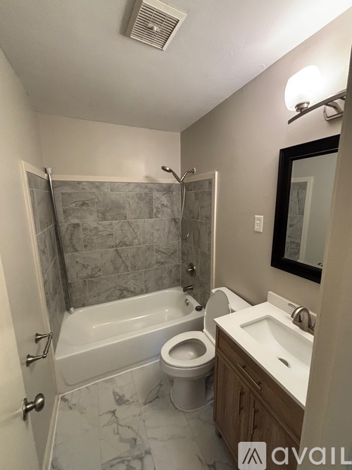 A bathroom with a toilet, sink, and bathtub.