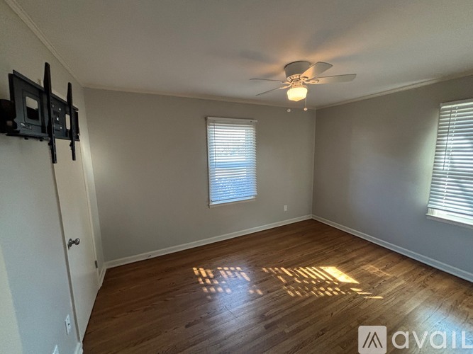 A room with a ceiling fan and wooden flooring.