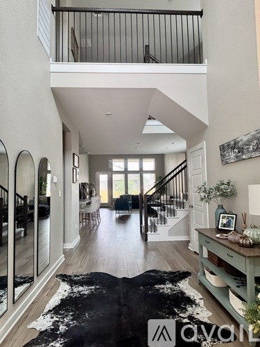A spacious hallway with a black and white cowhide rug in the center.