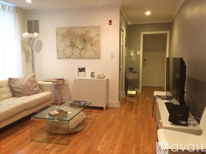 A living room with a glass coffee table and a white sofa.